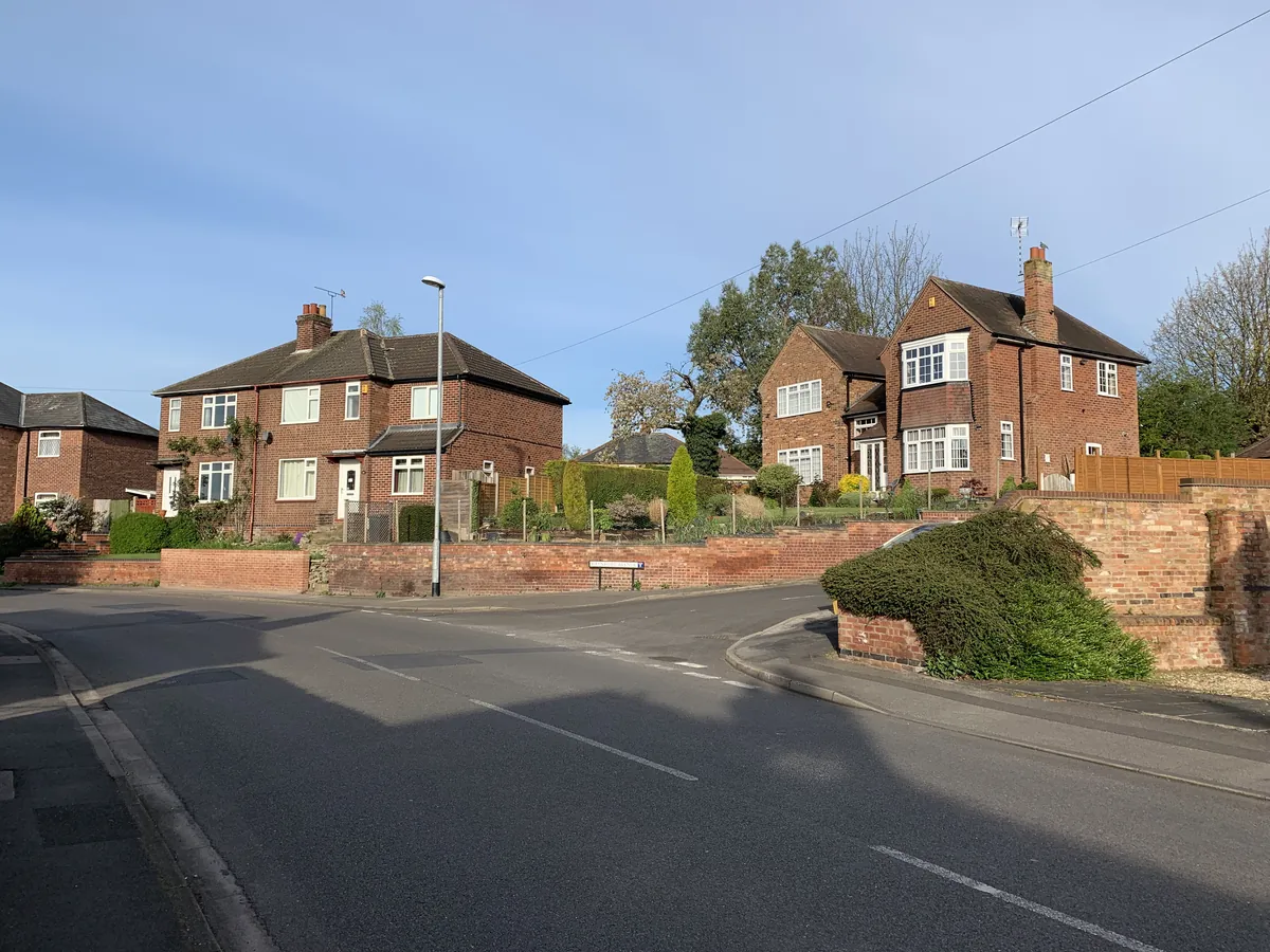 Brick semi-detached and detached houses with front gardens on Raynford Avenue in Chilwell