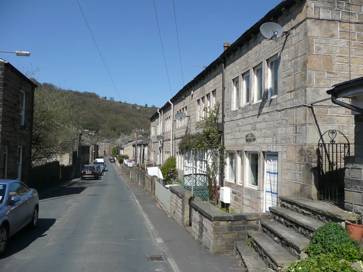 Stone terraced houses with steps up to their doors on Foster Lane, Hebden Bridge