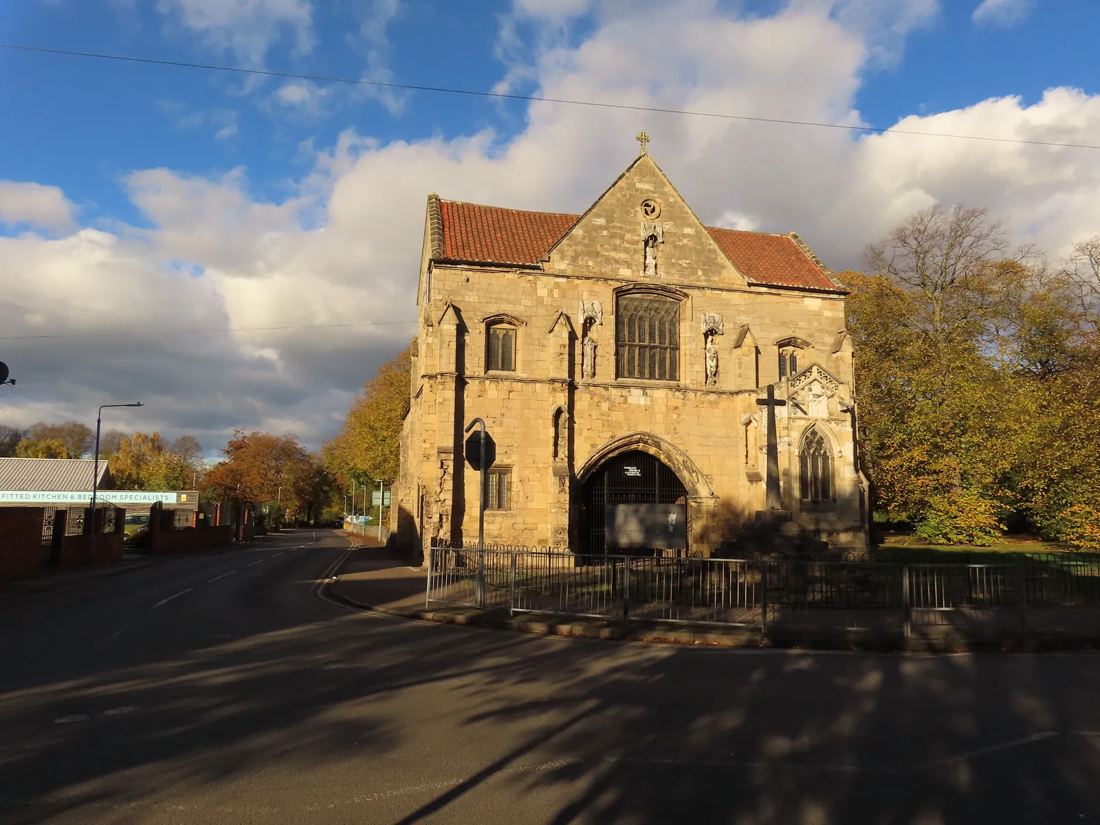 The medieval Priory Gatehouse in Worksop, lit by low autumn sun under a blue sky